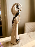 Vit och silverfärgad skulptur med två figurer i en omfamning, 27 cm hög.