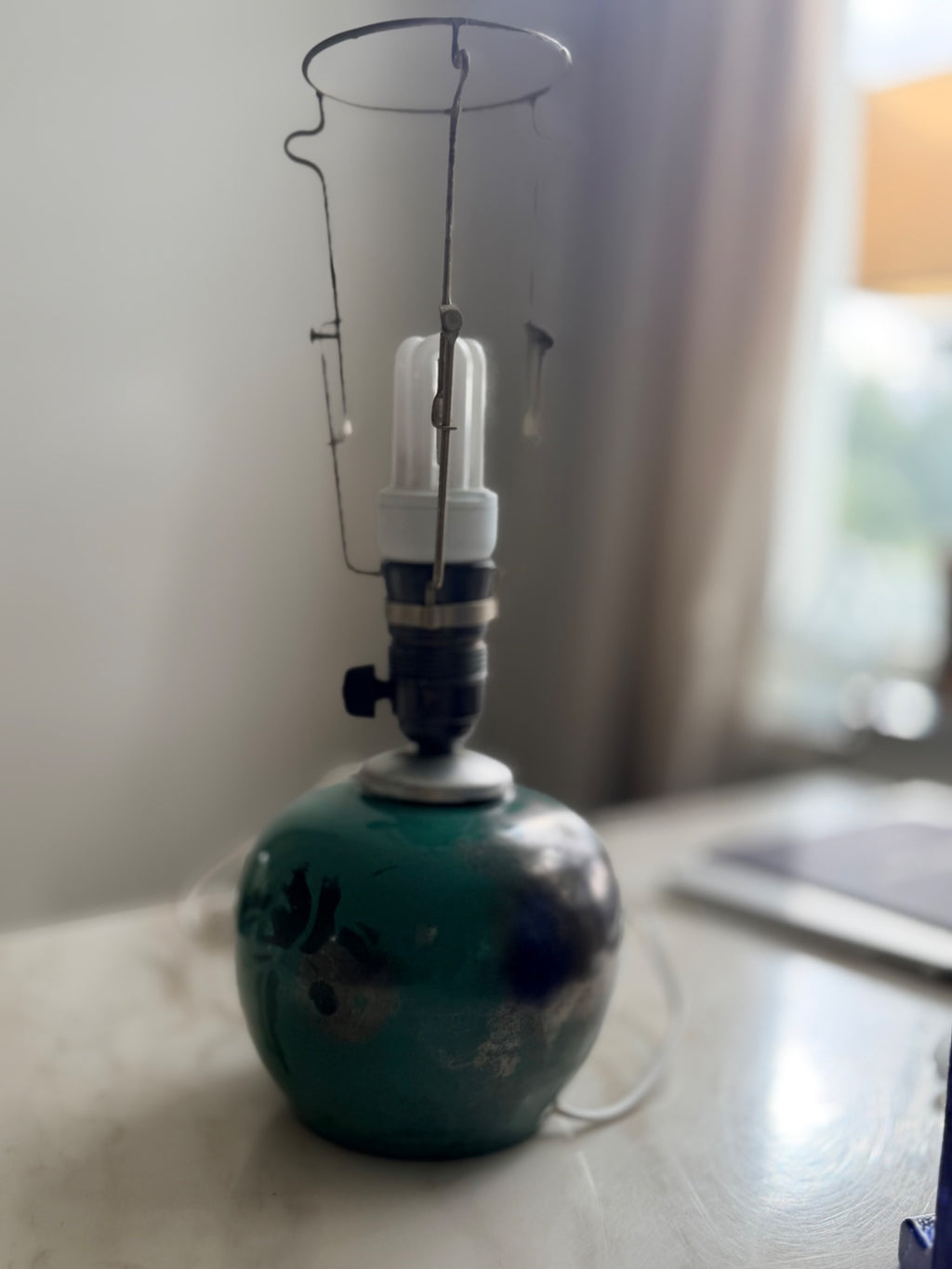 Bordslampa i grön keramik sedd från sidan, utan lampskärm