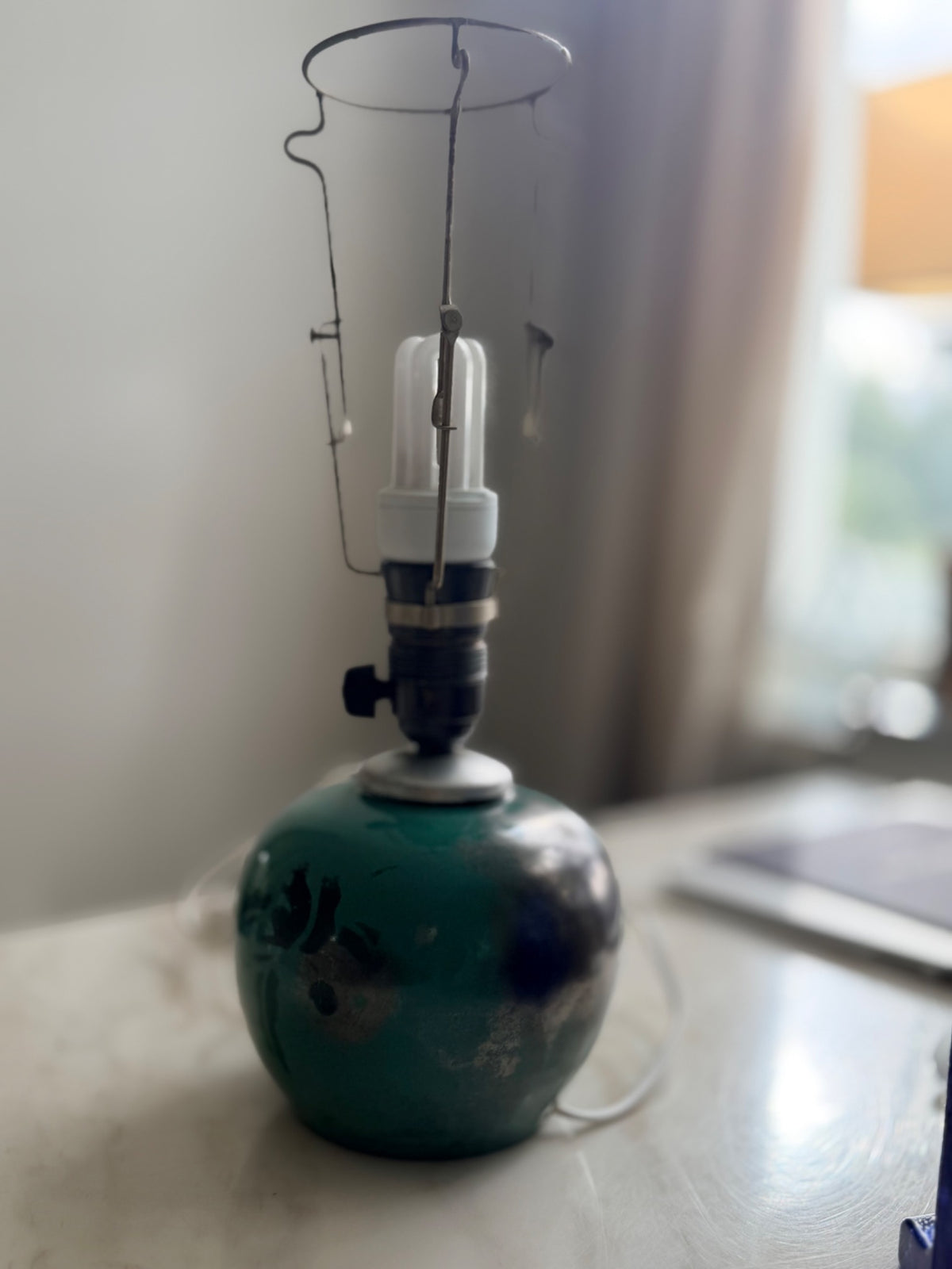 Bordslampa i grön keramik sedd från sidan, utan lampskärm